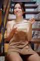 A woman sitting on a stairway holding a bowl of milk.