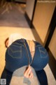 A woman in a pair of blue jeans with a zipper on her back.