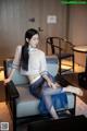 A woman sitting on a chair in a room.